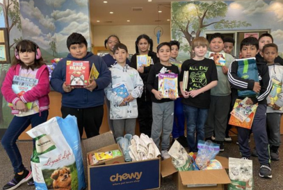  students holding items to donate